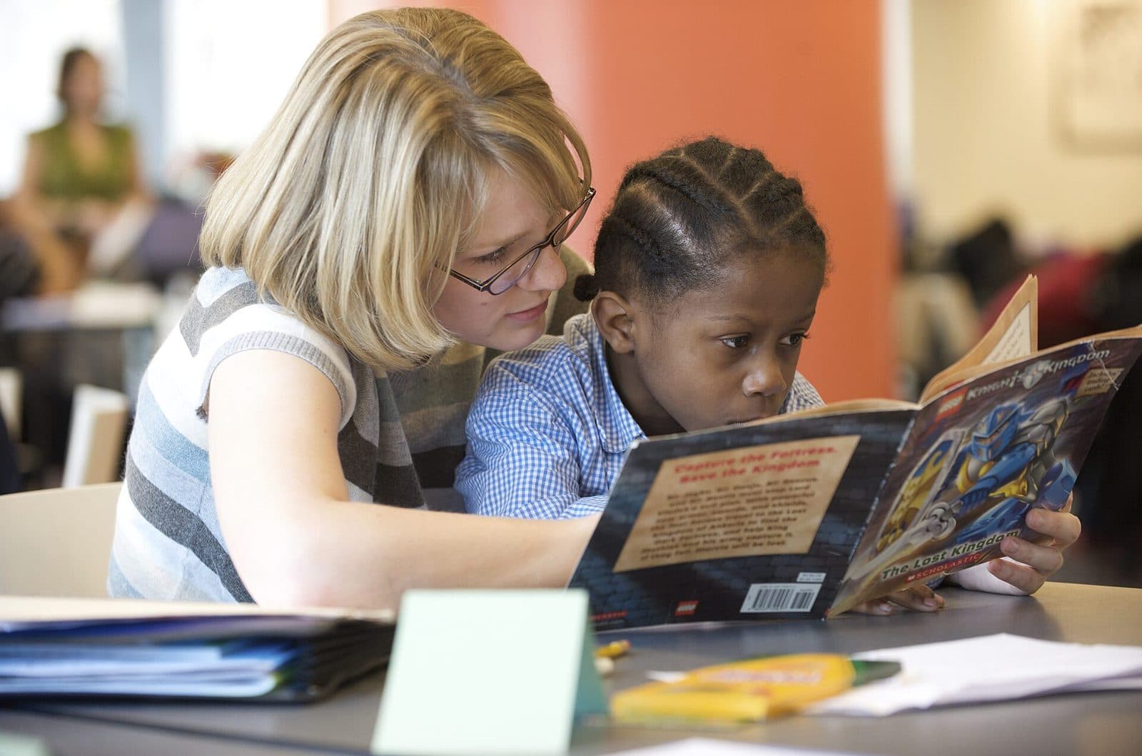 A tutor and a child looking at an illustrated book